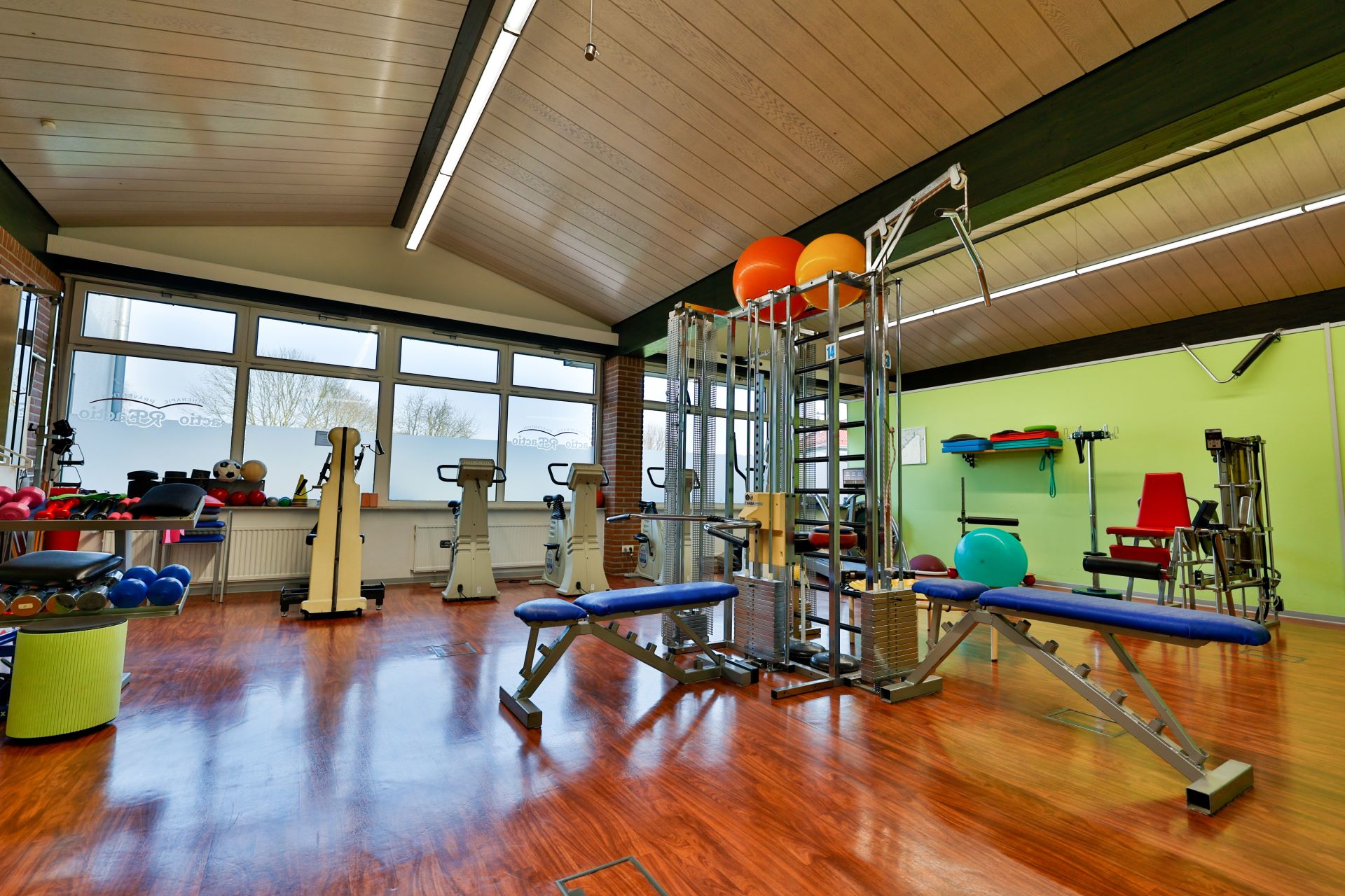 Ein heller Fitnessraum mit bunten Gymnastikbällen und modernen Fitnessgeräten
