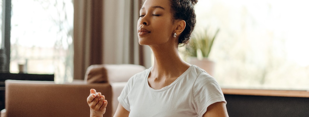 Porträt einer schönen afroamerikanischen Frau bei der Atemmeditation zu Hause