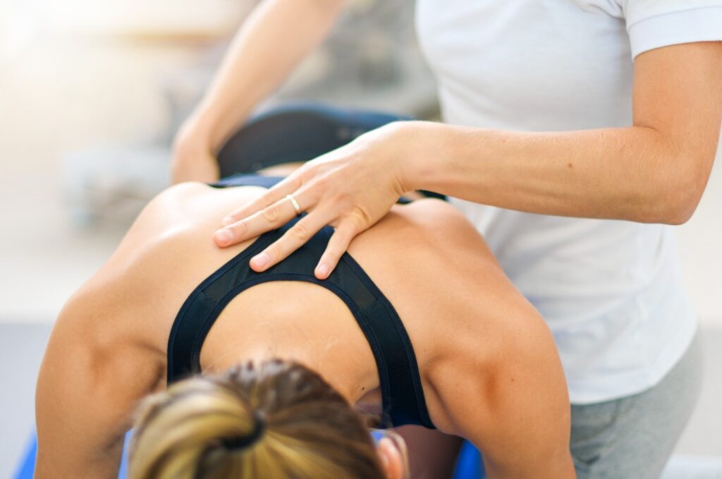 Physiotherapeut arbeitet mit einem Sportlerpatienten in einer Klinik, Detailansicht der behandelnden Hände.